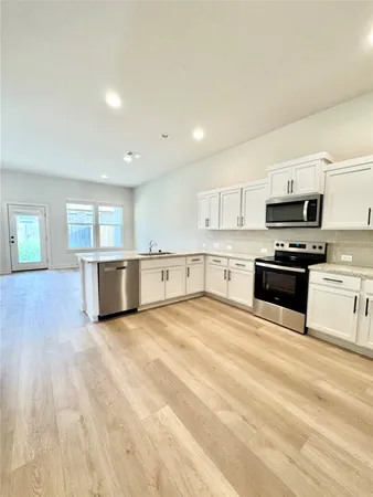 a view of large kitchen with stainless steel appliances cabinets