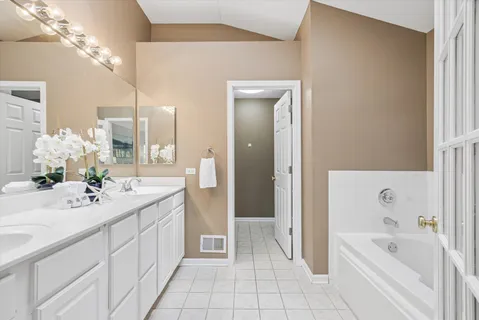 a bathroom with a tub sink and mirror