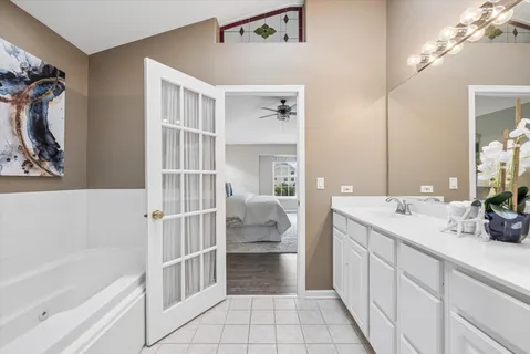a spacious bathroom with a double vanity sink a mirror and a bathtub