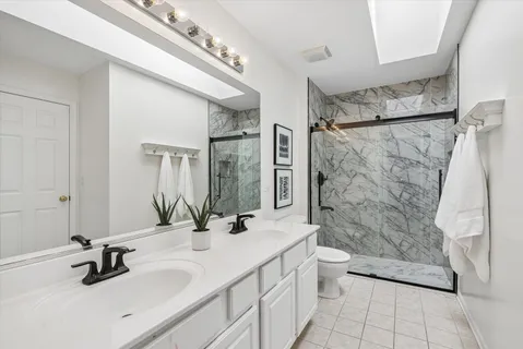 a bathroom with a double vanity sink toilet and shower
