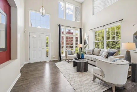 a living room with furniture large window and wooden floor