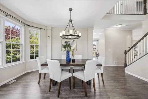 a dining room with furniture a chandelier and wooden floor