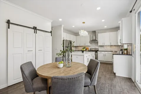 a kitchen with kitchen island a appliances dining table and chairs