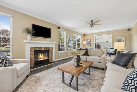 a living room with furniture a flat screen tv and a fireplace