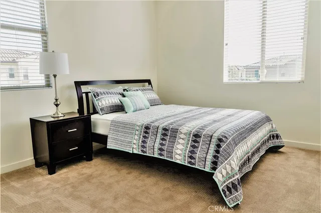 a large bed sitting in a bedroom next to a window