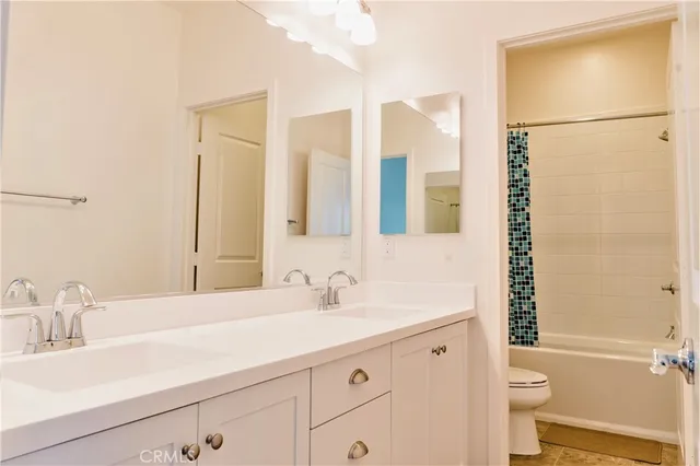a bathroom with a double vanity sink toilet and shower