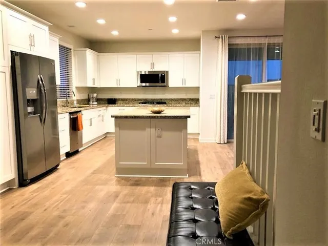 a kitchen with stainless steel appliances granite countertop a refrigerator and a stove