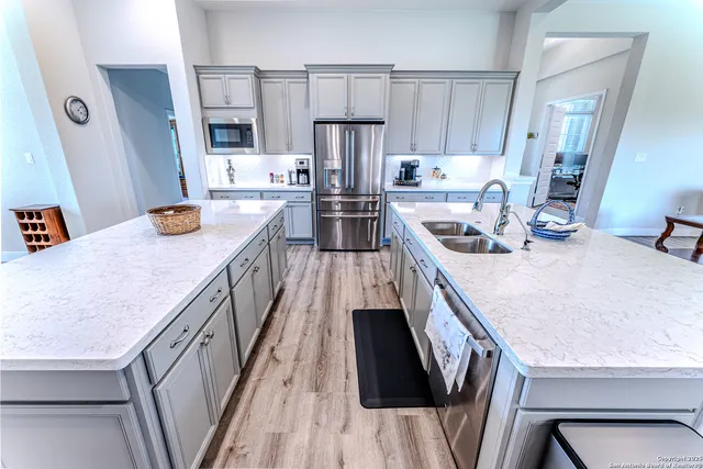 a kitchen with stainless steel appliances granite countertop a sink dishwasher stove and refrigerator