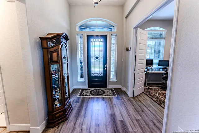 a view of a hallway with wooden floor and a living room