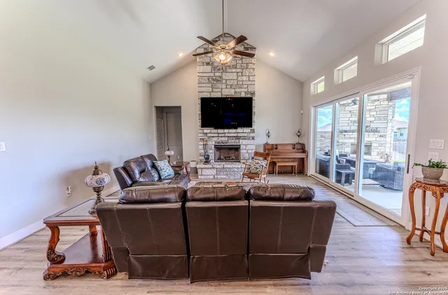 a living room with furniture a flat screen tv and a fireplace