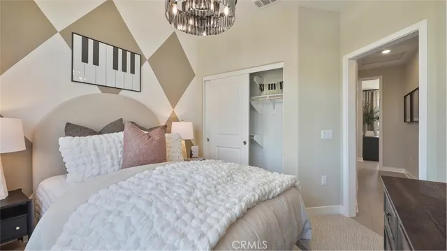 a bedroom with a large bed and a chandelier