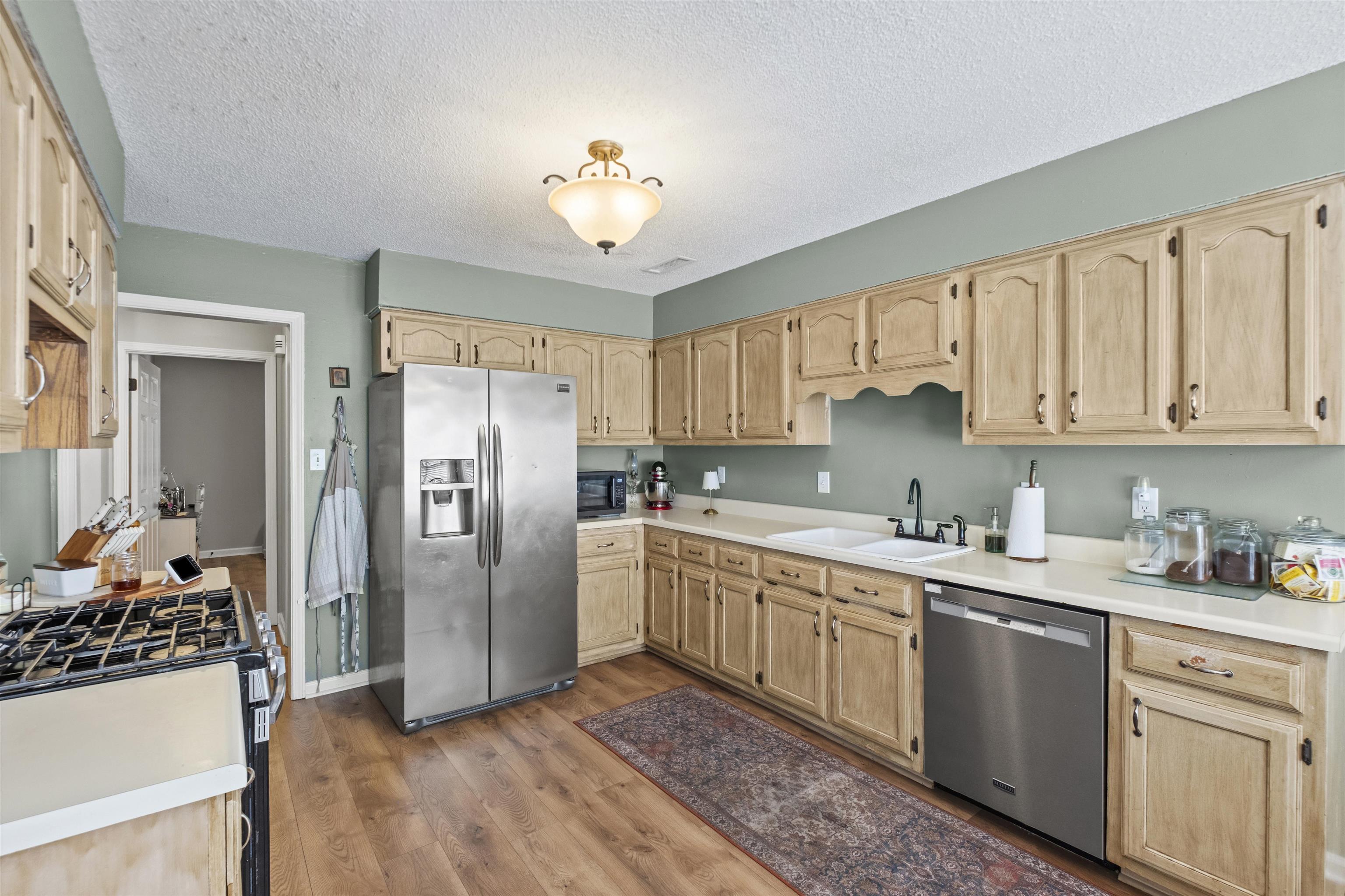 3601 Marshall Road Munford, TN 38058 - Photo 21 of 35 Kitchen featuring extensive light wood-finish cabinetry, light-toned countertops, wood-finish flooring, and a ceiling-mounted light fixture