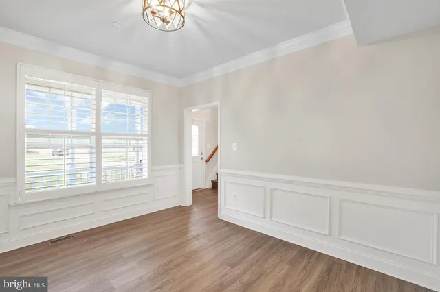 an empty room with wooden floor and window