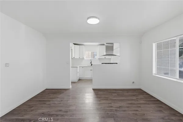 a view of a kitchen with white cabinets and wooden floor