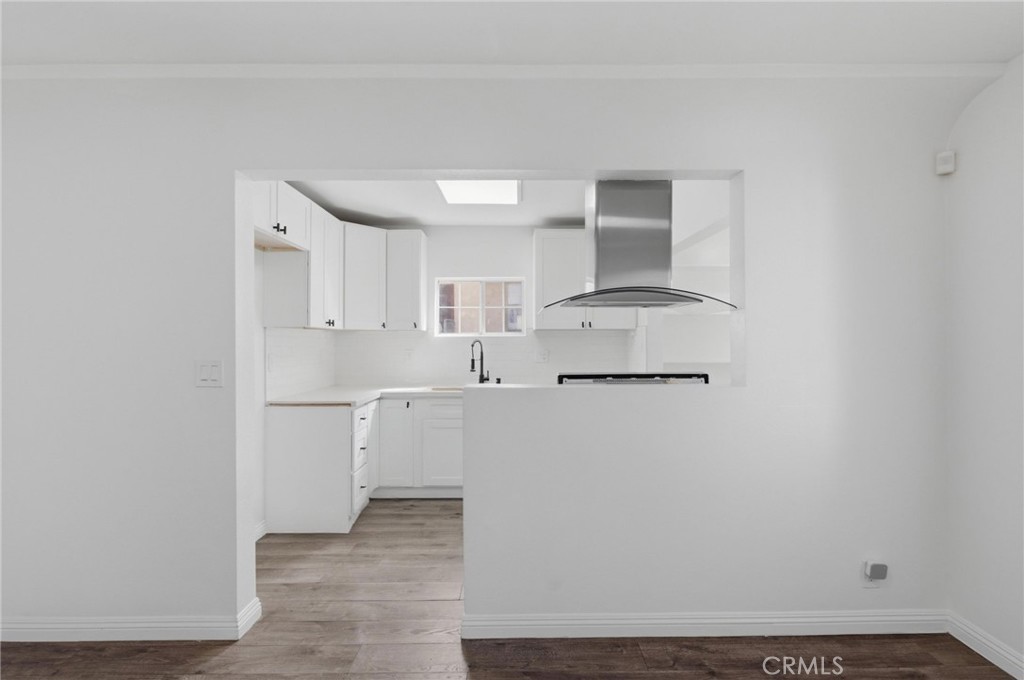 1311 West R Street Wilmington, CA 90744 - Photo 19 of 65 a view of a kitchen with white cabinets and wooden floor
