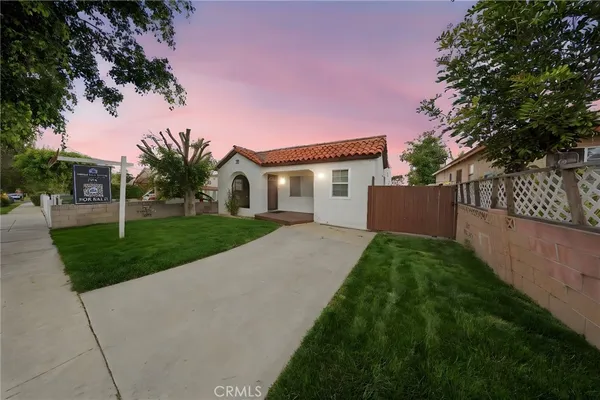 a view of backyard of house with wooden fence