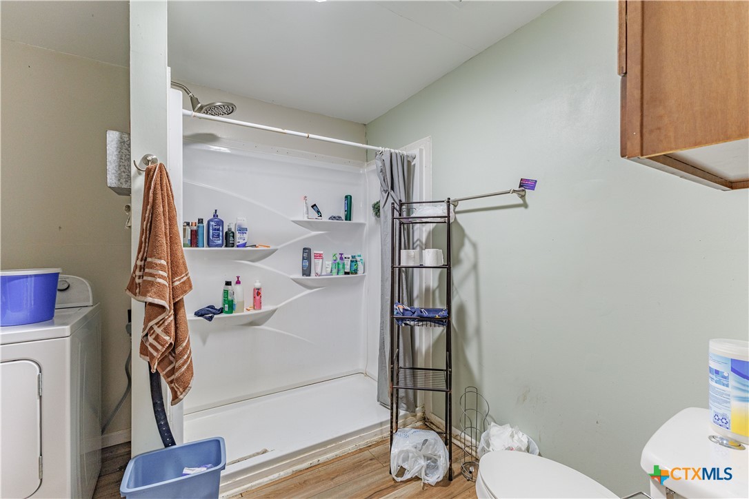 5472 Knob Creek Spur Temple, TX 76501 - Photo 5 of 27 a bathroom with a refrigerator and a wooden floor