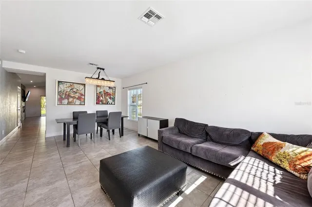 a living room with furniture and a dining table