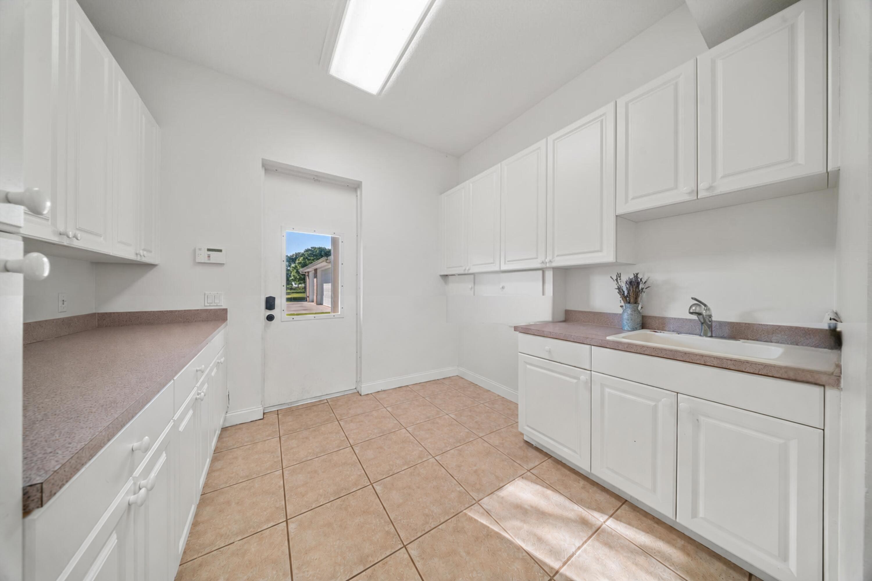 8686 Andrews Avenue Fort Pierce, FL 34945 - Photo 35 of 76 a kitchen with granite countertop white cabinets and sink