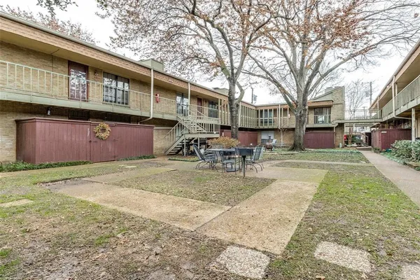 a backyard of a house with table and chairs