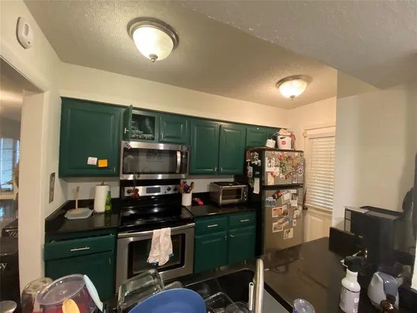 a kitchen with stainless steel appliances a stove refrigerator and microwave