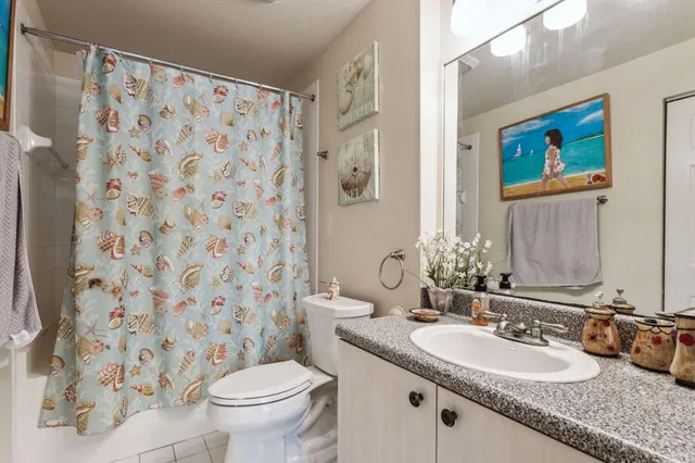 a bathroom with a granite countertop sink a toilet and a mirror