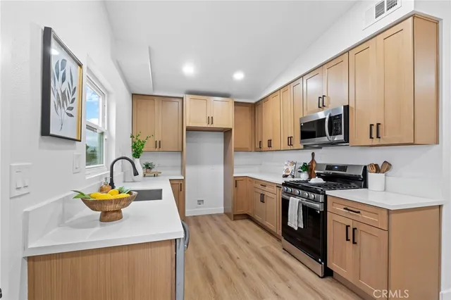 a kitchen with stainless steel appliances granite countertop a sink stove and refrigerator