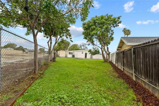 a view of a house with backyard and a tree
