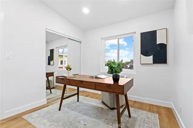 a view of a workspace room with wooden floor and a potted plant