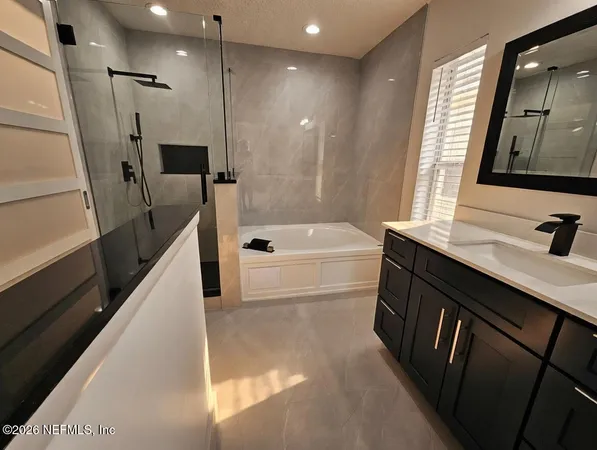 a bathroom with a sink a tub and a mirror
