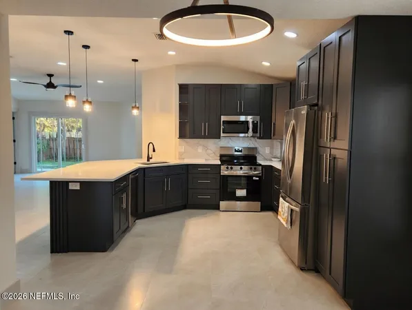 a large kitchen with a large counter top appliances and cabinets
