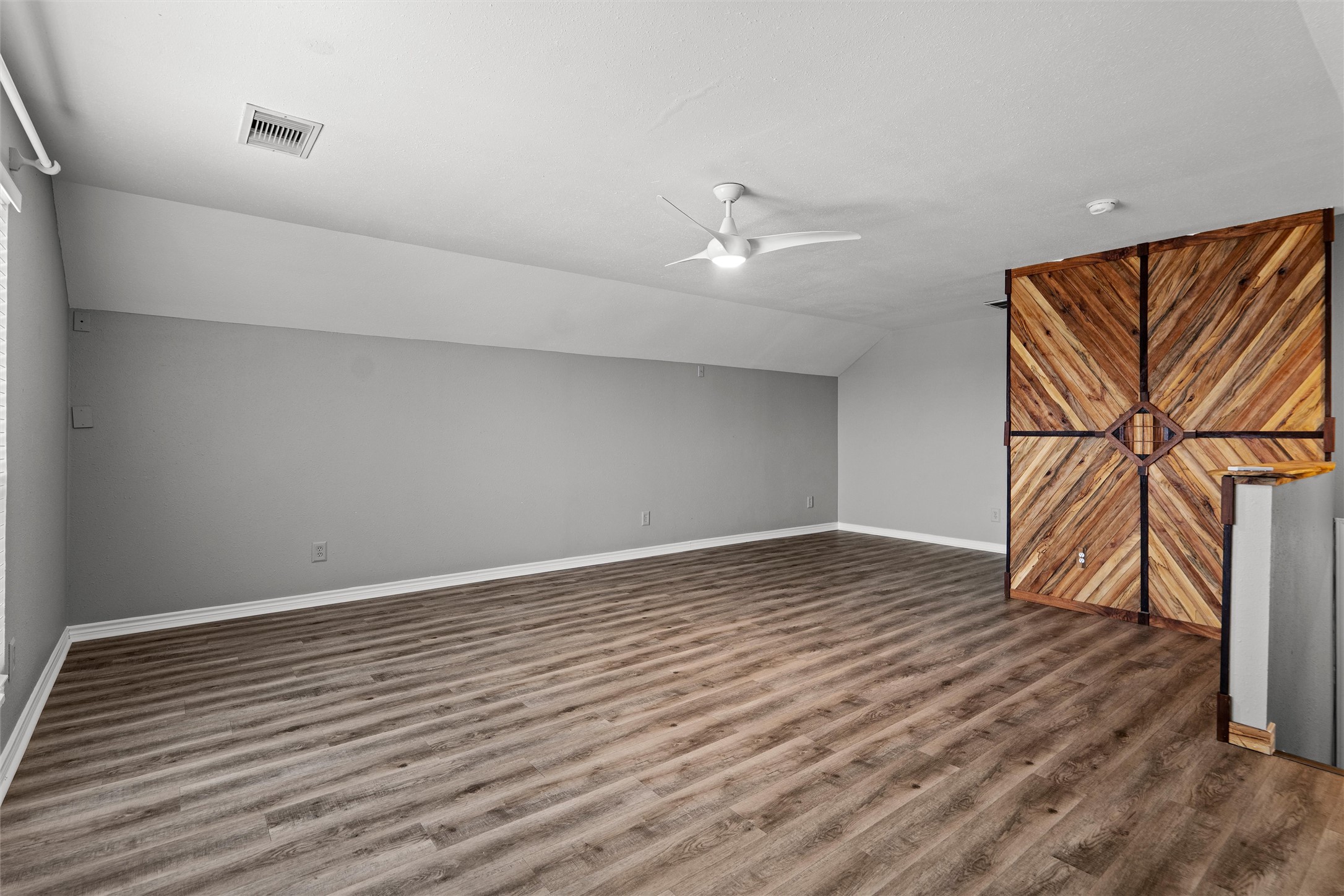 7000 Colberg Court Austin, TX 78749 - Photo 31 of 40 Bonus room/Game Room/Media Room has Vast open-concept space featuring rich wood flooring and a distinctive accent wall.