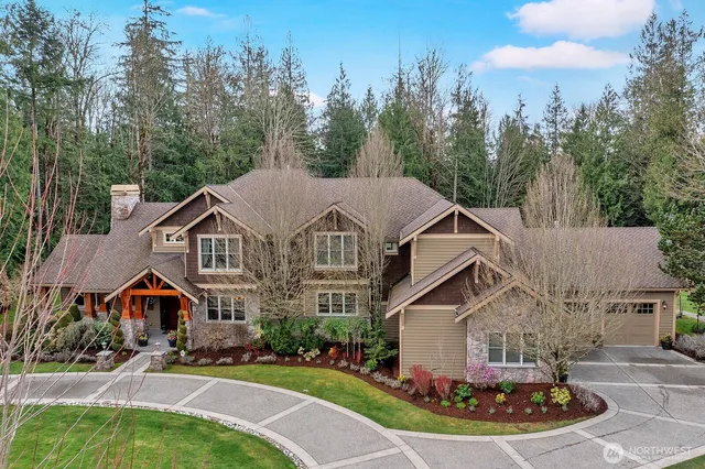 a front view of a house with a garden and trees