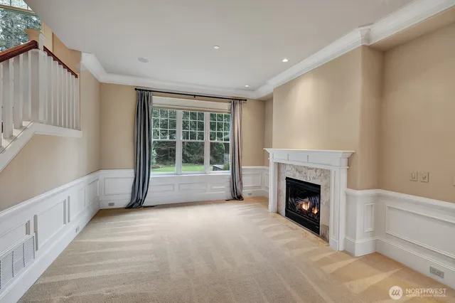 a view of an empty room with a fireplace and a window
