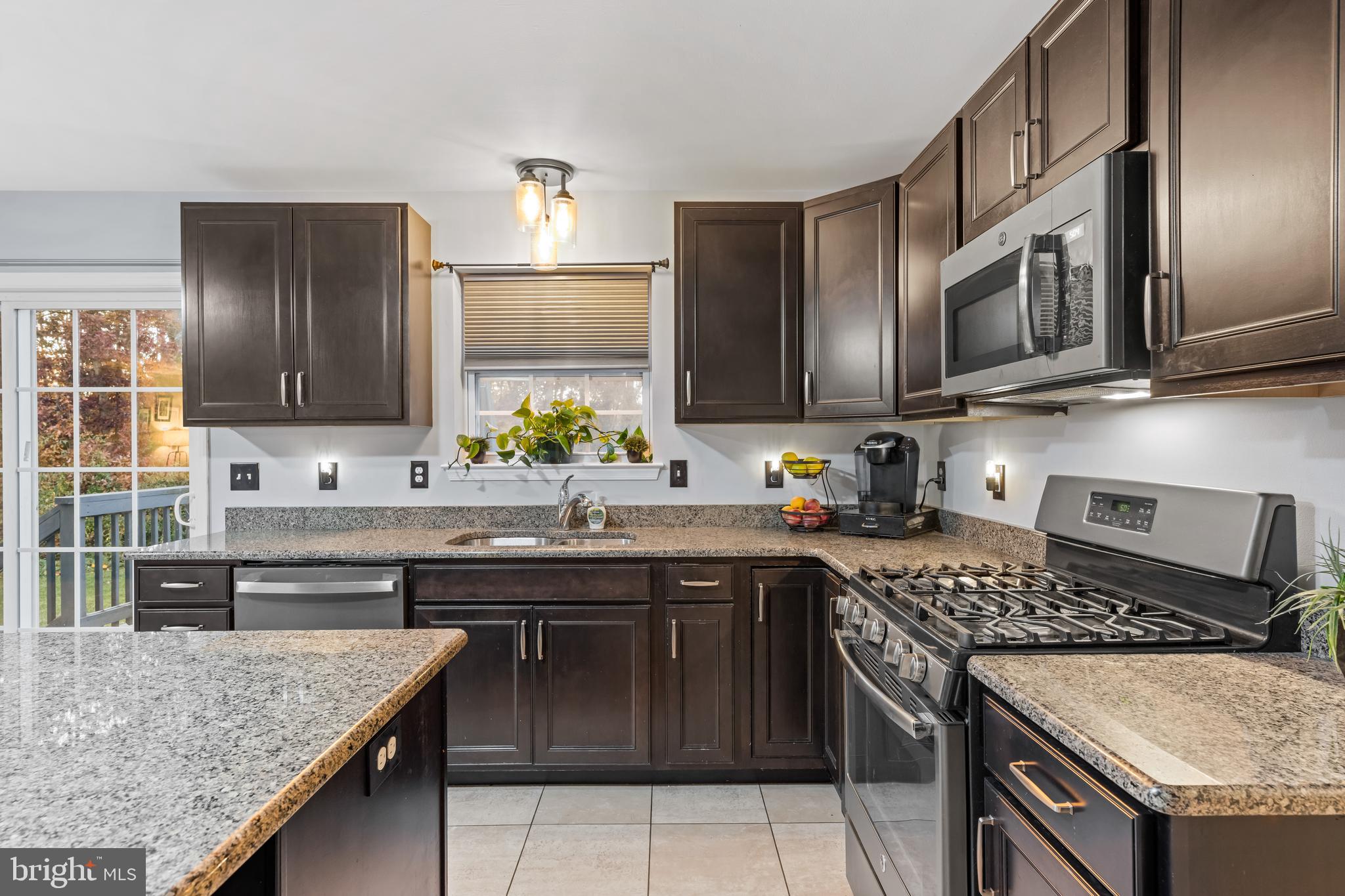 108 Nottingham Lane Newfield, NJ 08344 - Photo 24 of 39 a kitchen with stainless steel appliances granite countertop a stove a sink and a microwave