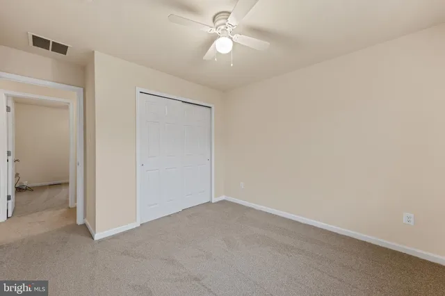 an empty room with a ceiling fan and a fan
