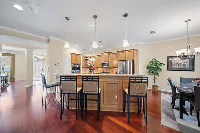 a view of a dining room and livingroom with furniture wooden floor a chandelier