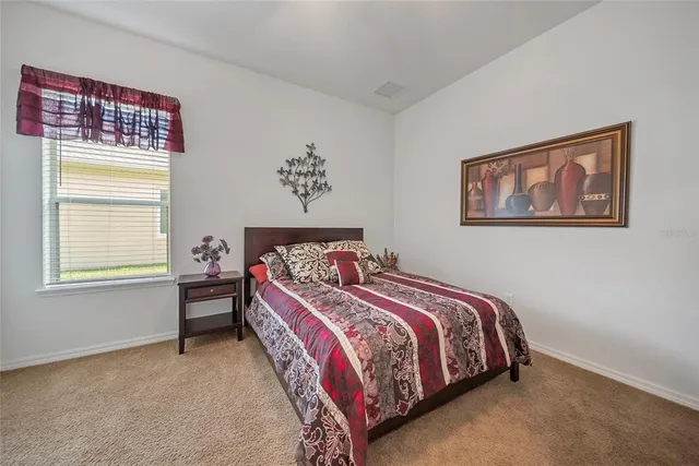 a bedroom with a bed and a painting on the wall