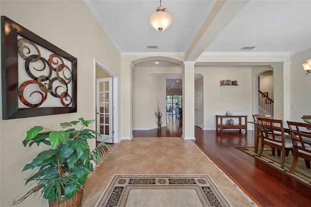 a hall with wooden floor and a potted plant
