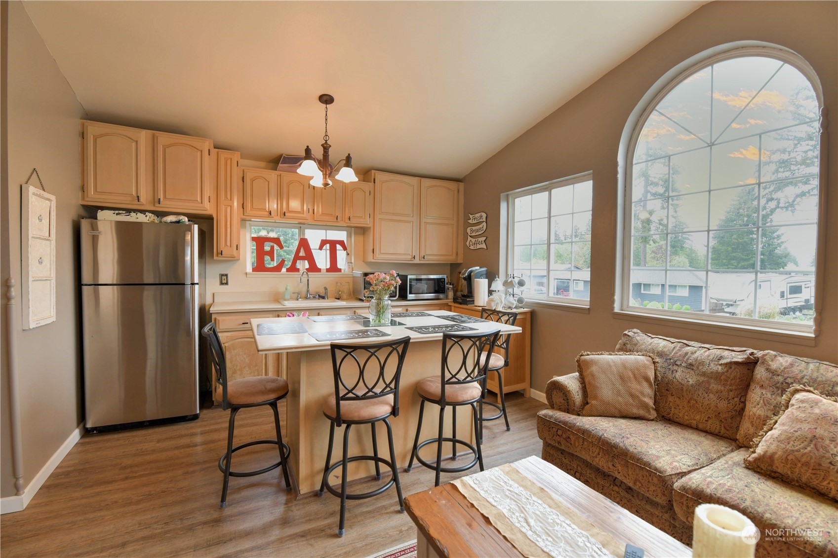 1151 Redmond Avenue Northeast Renton, WA 98056 - Photo 15 of 23 a kitchen with stainless steel appliances granite countertop a refrigerator a sink dishwasher a dining table and chairs with wooden floor