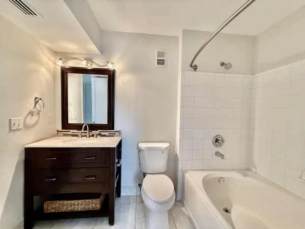 a bathroom with a granite countertop toilet sink and mirror