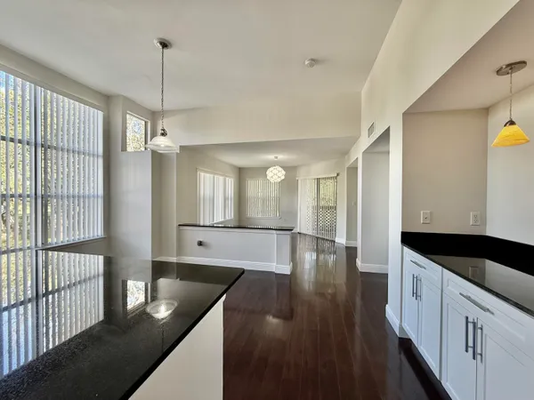a large kitchen with kitchen island granite countertop a large window and stainless steel appliances