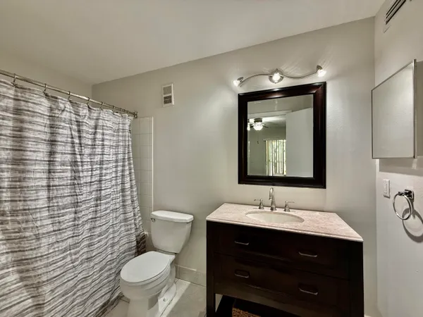 a bathroom with a sink vanity mirror and toilet