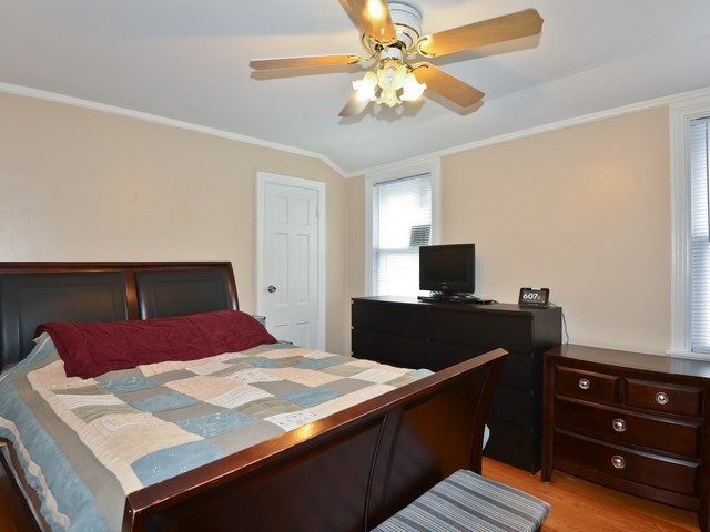 6015 West Barry Avenue Chicago, IL 60634 - Photo 6 of 10 a bedroom with a bed and a flat screen tv
