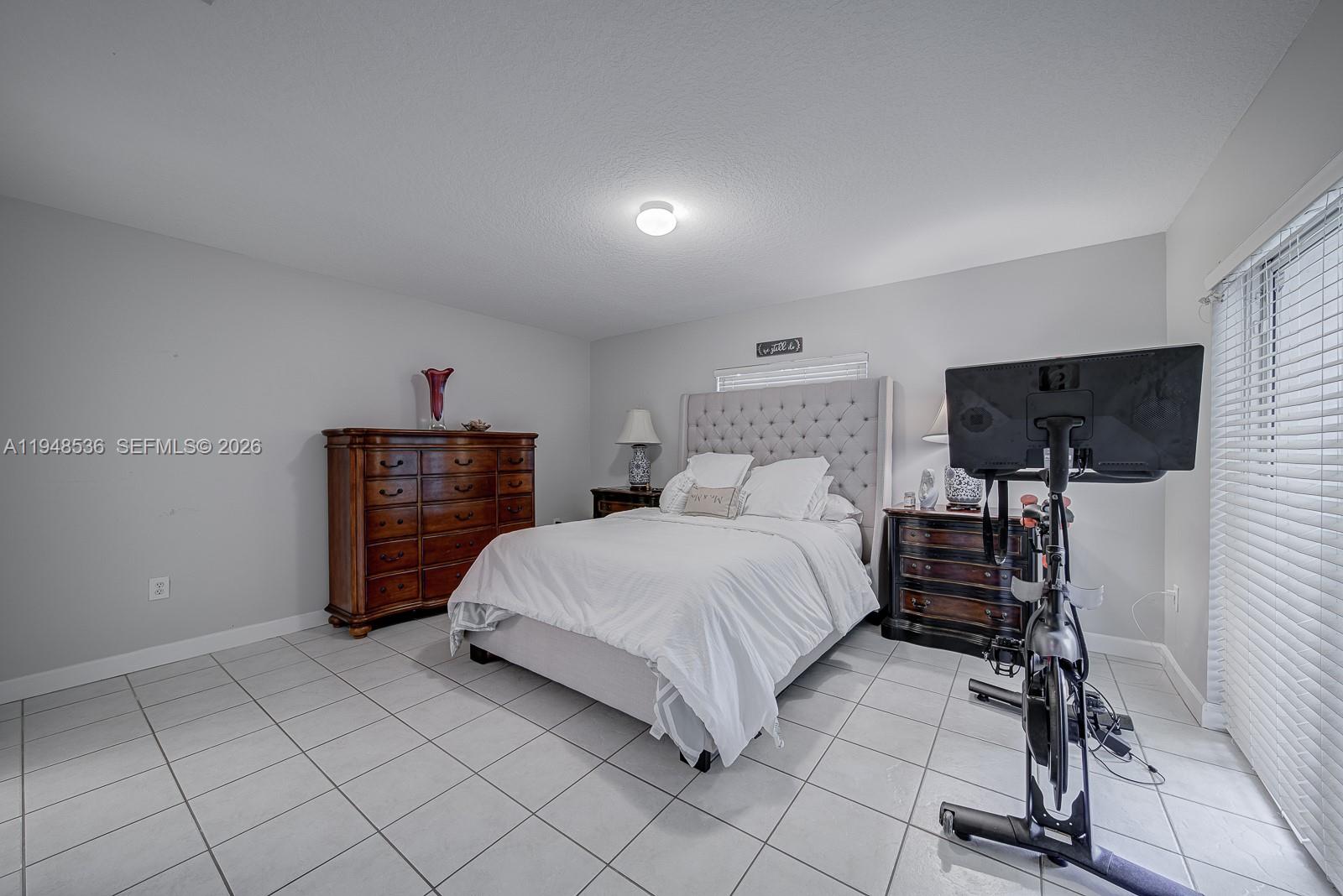 18128 Southwest 151st Avenue Miami, FL 33187 - Photo 12 of 39 a bedroom with a bed and a lamp on table