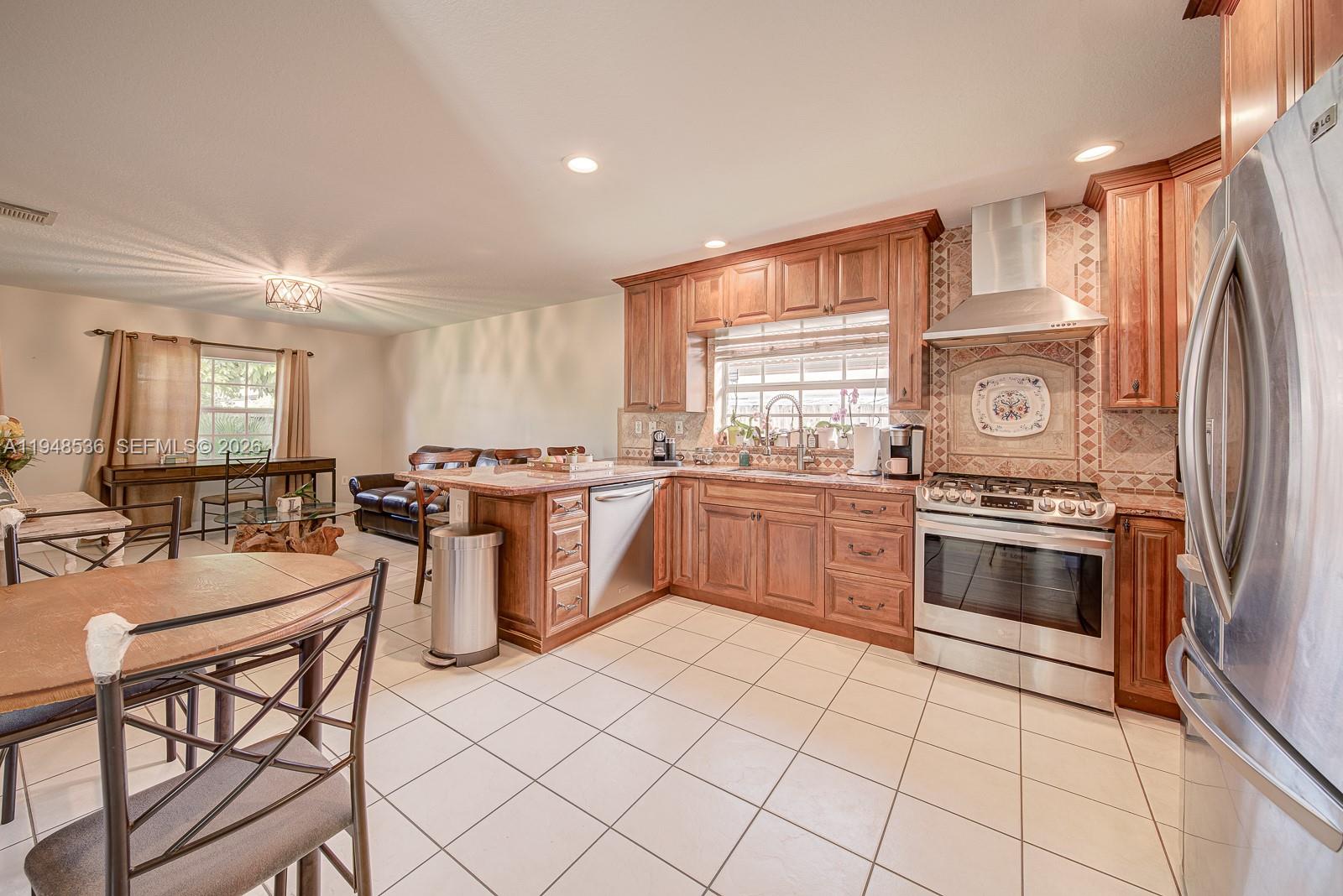 18128 Southwest 151st Avenue Miami, FL 33187 - Photo 20 of 39 a kitchen with stainless steel appliances granite countertop a stove a sink dishwasher and a refrigerator