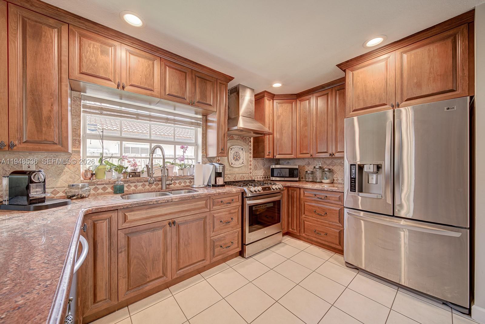 18128 Southwest 151st Avenue Miami, FL 33187 - Photo 24 of 39 a kitchen with a refrigerator stove top oven and sink