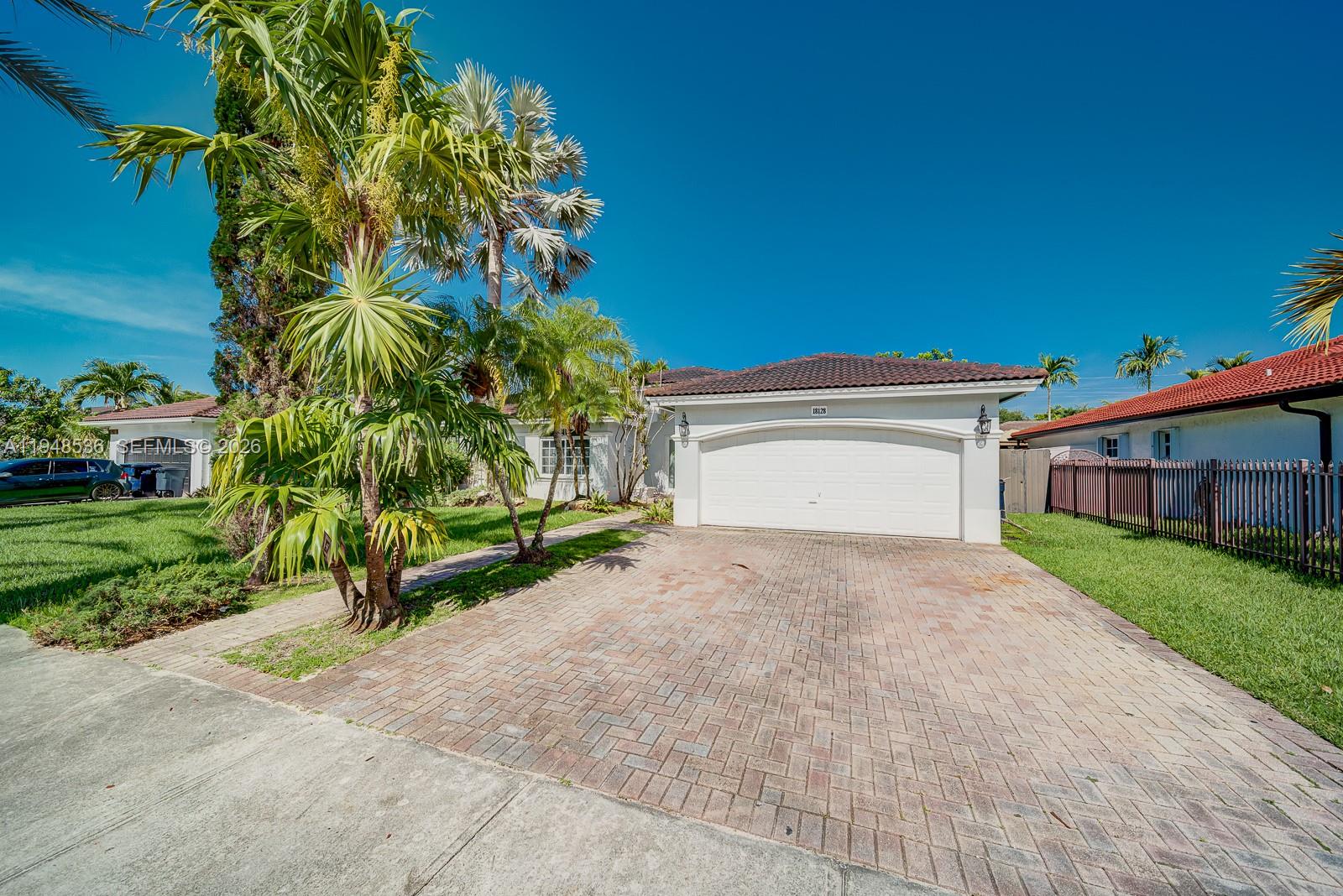 18128 Southwest 151st Avenue Miami, FL 33187 - Photo 3 of 39 a white house with a small yard and a large parking space