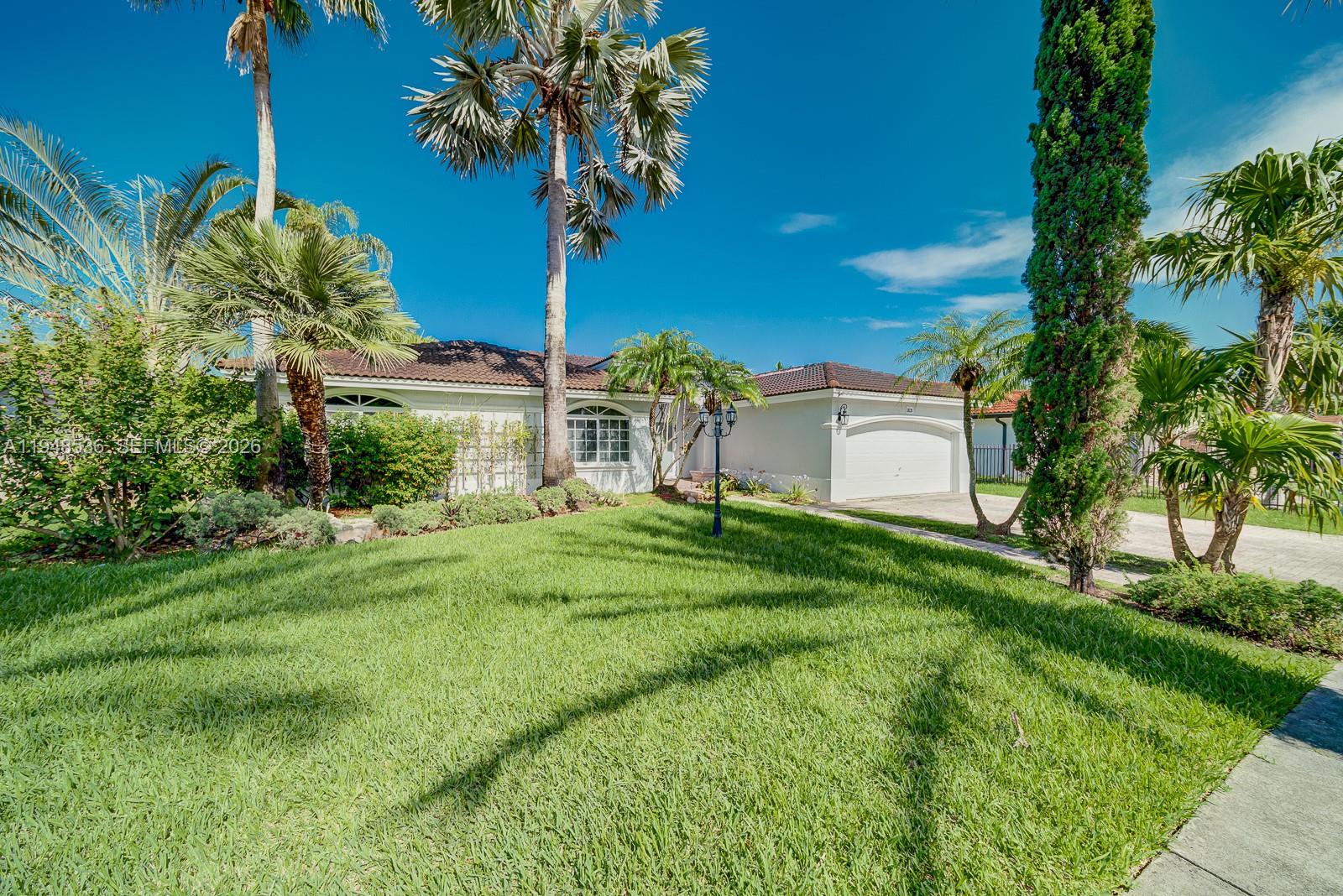 18128 Southwest 151st Avenue Miami, FL 33187 - Photo 4 of 39 a front view of a house with garden