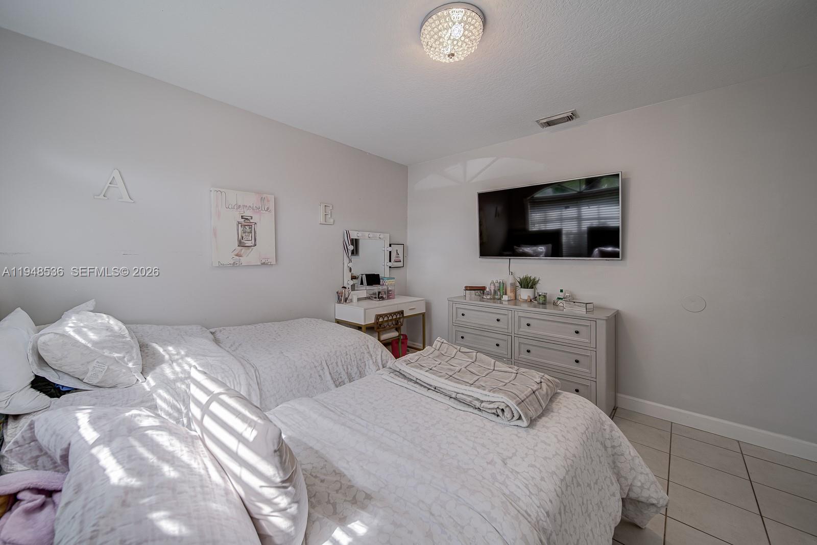 18128 Southwest 151st Avenue Miami, FL 33187 - Photo 9 of 39 a bedroom with a bed and a flat screen tv